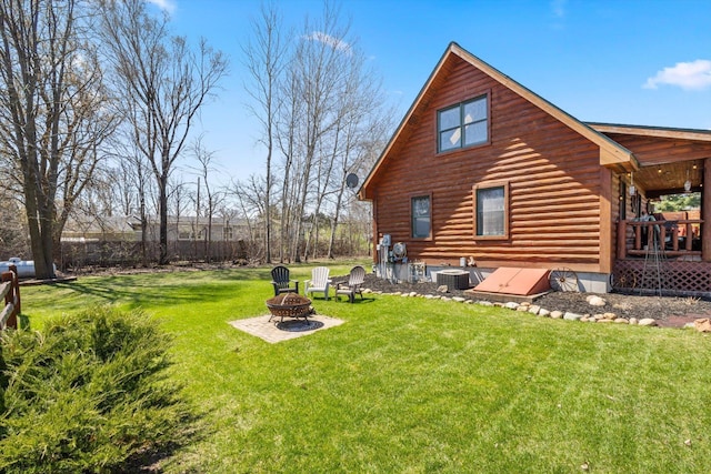 510 State Rd Unit 35, Centuria, WI 54024 - rear view of house with a lawn, central AC unit, an outdoor fire pit, and log exterior