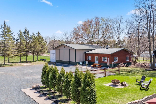 510 State Rd Unit 35, Centuria, WI 54024 - rear view of house with a lawn, an outdoor fire pit, and metal roof