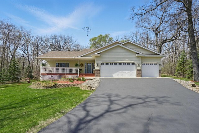single story home featuring a garage, a front lawn, aphalt driveway, brick siding, and a porch