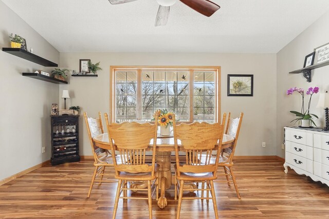 dining area featuring light wood-style floors, baseboards, and ceiling fan