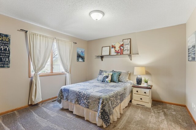 bedroom with baseboards, carpet flooring, and a textured ceiling
