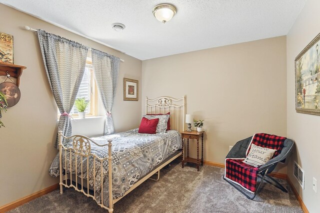 bedroom featuring visible vents, a textured ceiling, carpet, and baseboards
