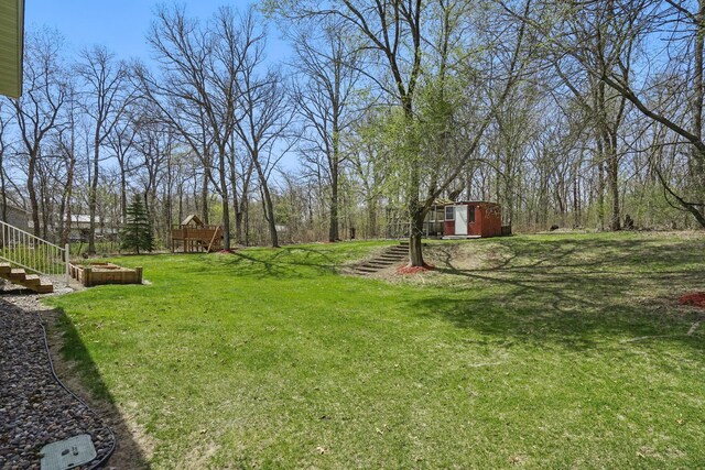 view of yard featuring stairs, a shed, and an outbuilding