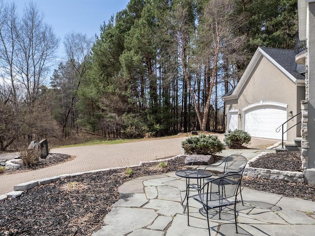 view of patio / terrace featuring a garage and driveway