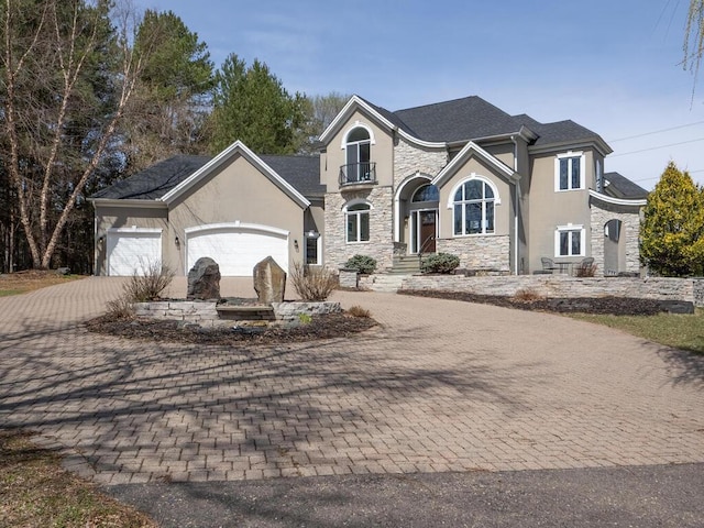 view of front of property with decorative driveway, stone siding, stucco siding, and a garage