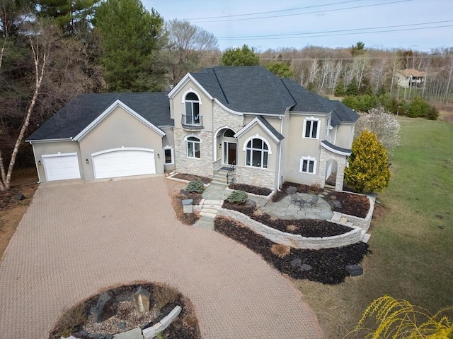 view of front of home with stucco siding, decorative driveway, a garage, stone siding, and a front yard