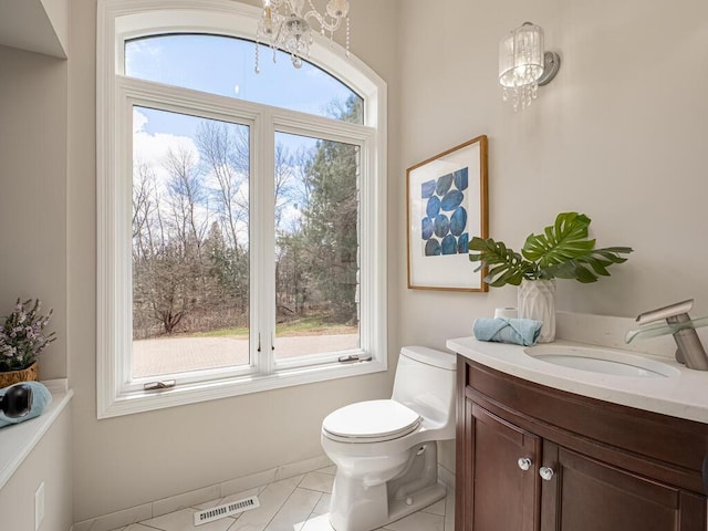 bathroom featuring visible vents, baseboards, an inviting chandelier, toilet, and vanity