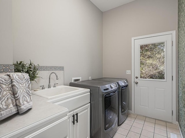 clothes washing area with light tile patterned floors, cabinet space, and washing machine and dryer