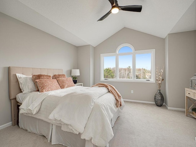 bedroom featuring baseboards, ceiling fan, light colored carpet, and vaulted ceiling