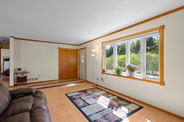7830 Country Ln, Lino Lakes, MN 55014 - living area with wood finished floors, ornamental molding, baseboards, and a textured ceiling