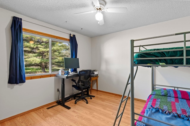 7830 Country Ln, Lino Lakes, MN 55014 - bedroom with wood finished floors, a textured ceiling, baseboards, ceiling fan, and an office area