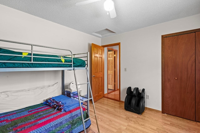 7830 Country Ln, Lino Lakes, MN 55014 - bedroom featuring light wood-style flooring, a textured ceiling, a closet, a ceiling fan, and baseboards
