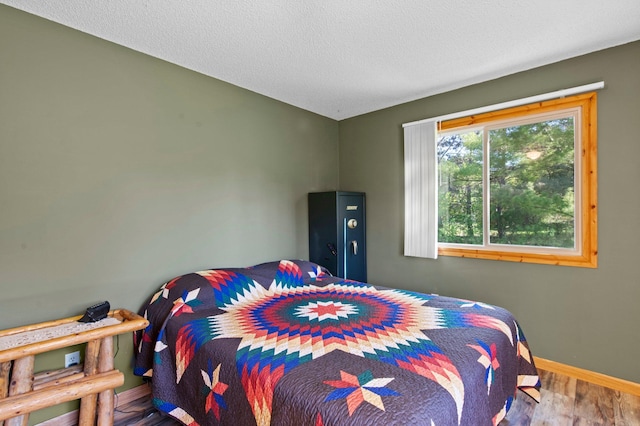 7830 Country Ln, Lino Lakes, MN 55014 - bedroom with wood finished floors, baseboards, and a textured ceiling