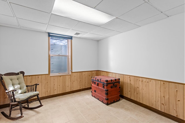 7830 Country Ln, Lino Lakes, MN 55014 - living area with a wainscoted wall, a drop ceiling, wooden walls, and light tile patterned floors