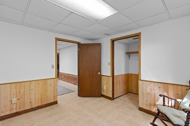 7830 Country Ln, Lino Lakes, MN 55014 - unfurnished room featuring wainscoting, wood walls, and a drop ceiling