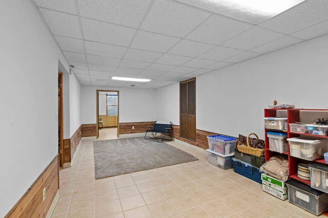 7830 Country Ln, Lino Lakes, MN 55014 - rec room with a paneled ceiling, light tile patterned floors, a wainscoted wall, and wooden walls