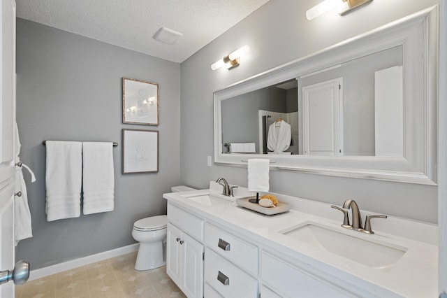 full bath with a textured ceiling, baseboards, toilet, and a sink