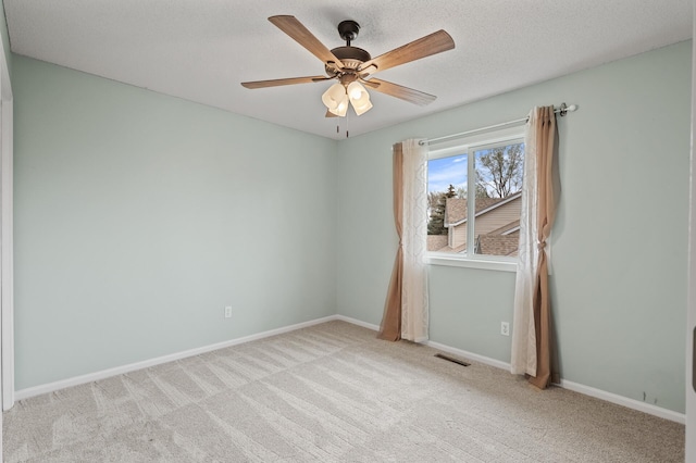 empty room with visible vents, baseboards, ceiling fan, and carpet floors