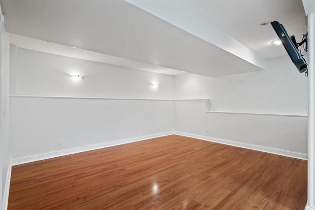 finished below grade area featuring baseboards and wood finished floors