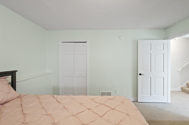 carpeted bedroom with a closet, visible vents, and baseboards