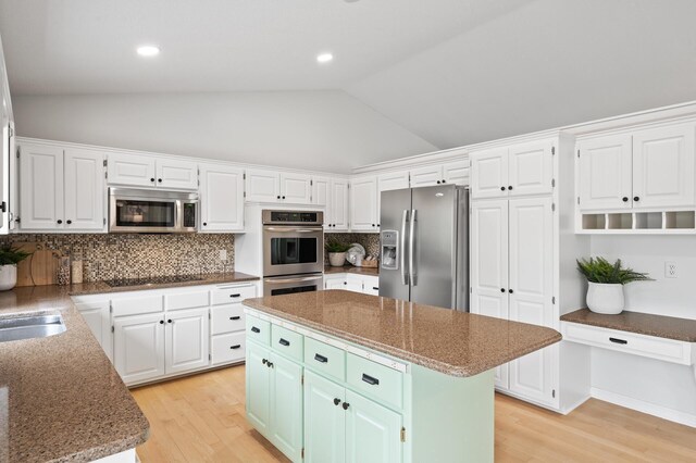 kitchen featuring vaulted ceiling, white cabinetry, stainless steel appliances, and light wood finished floors