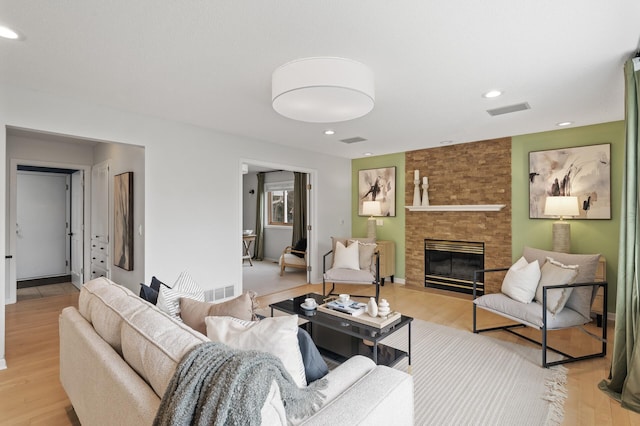 living area with light wood finished floors, visible vents, a large fireplace, and recessed lighting