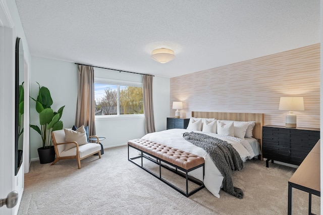 carpeted bedroom with a textured ceiling, baseboards, and an accent wall