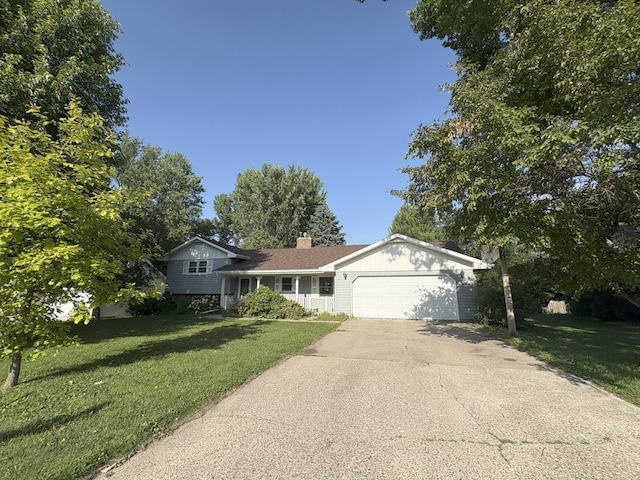 829 Church St, Saint Peter, MN 56082 - split level home with an attached garage, concrete driveway, a front yard, and a chimney