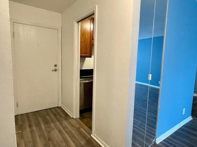 hallway featuring dark wood-style flooring and baseboards