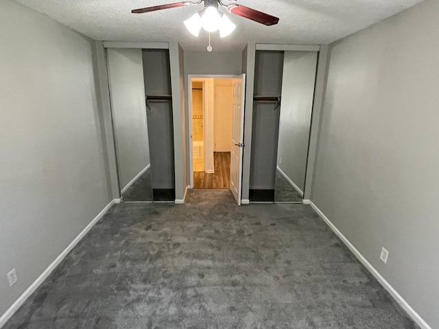 unfurnished bedroom featuring two closets, carpet flooring, baseboards, and ceiling fan
