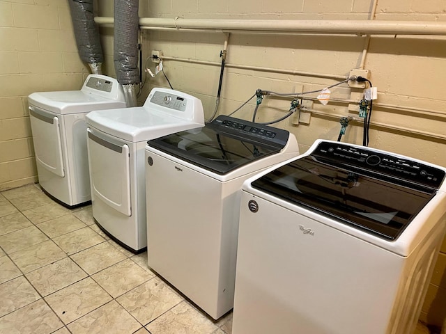 washroom featuring separate washer and dryer and concrete block wall