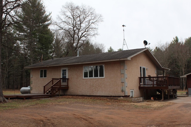 14879 Benson Rd, Grantsburg, WI 54840 - back of property with a wooden deck and stucco siding