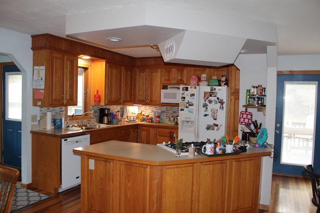 14879 Benson Rd, Grantsburg, WI 54840 - kitchen featuring decorative backsplash, brown cabinetry, a sink, white appliances, and dark wood-type flooring