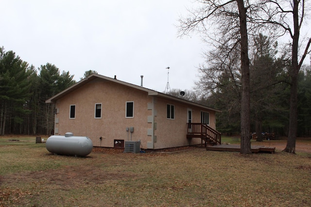 14879 Benson Rd, Grantsburg, WI 54840 - view of side of home featuring central air condition unit, stucco siding, and a yard