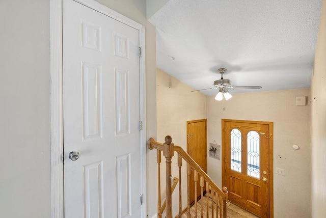 entrance foyer featuring a ceiling fan and a textured ceiling