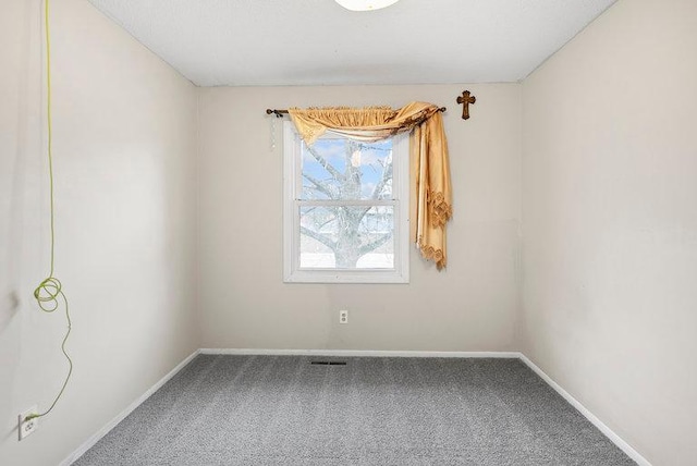 spare room with baseboards and carpet