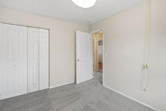 unfurnished bedroom with a closet, baseboards, and carpet flooring