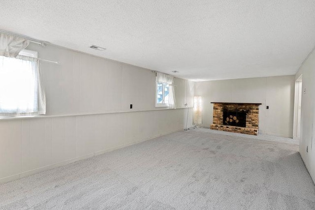 unfurnished living room featuring carpet floors, a textured ceiling, and visible vents