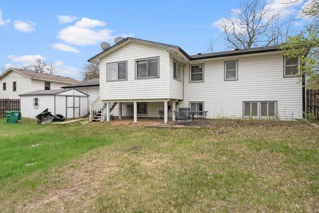 rear view of house featuring a storage unit, an outdoor structure, fence, and a yard