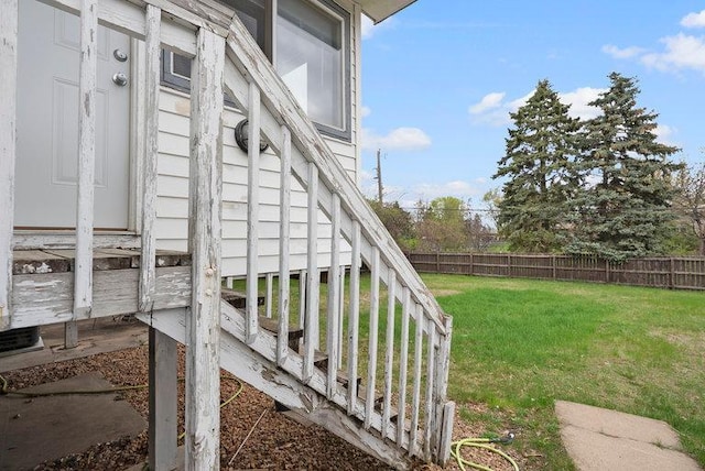 view of property exterior with fence and a lawn