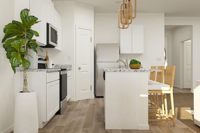 10213 Twin Lakes Pkwy NW, Elk River, MN 55330 - kitchen featuring appliances with stainless steel finishes, light wood-type flooring, an island with sink, and a breakfast bar