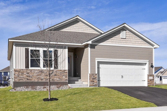 10213 Twin Lakes Pkwy NW, Elk River, MN 55330 - view of front of home with stone siding, a front lawn, driveway, a shingled roof, and cooling unit
