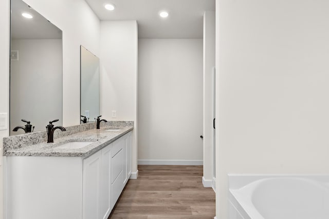 10213 Twin Lakes Pkwy NW, Elk River, MN 55330 - full bathroom with double vanity, a tub to relax in, wood finished floors, and recessed lighting