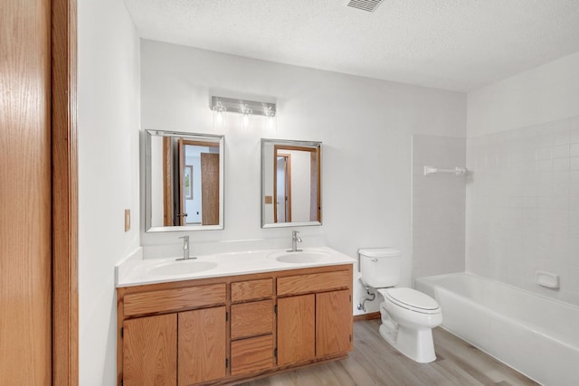 bathroom with double vanity, toilet, a sink, and wood finished floors