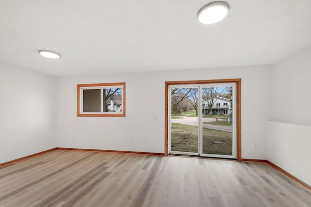unfurnished room featuring baseboards and wood finished floors