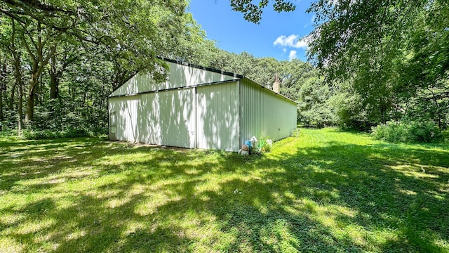 view of pole building featuring a yard and a view of trees
