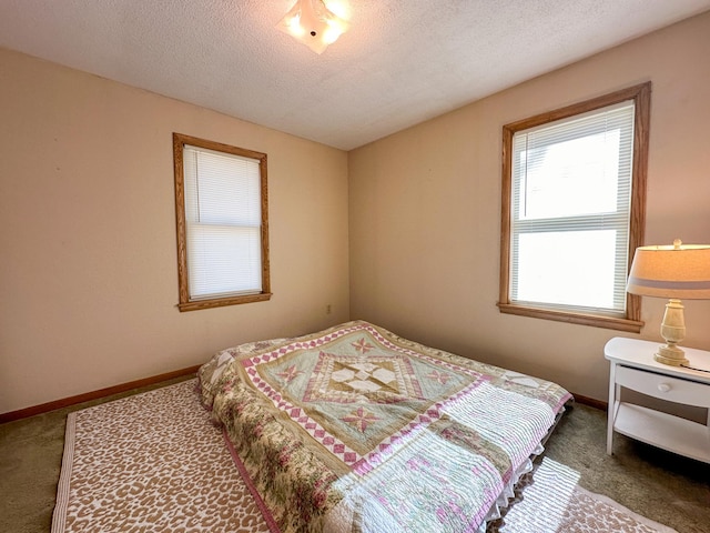 bedroom featuring a textured ceiling, carpet flooring, and baseboards