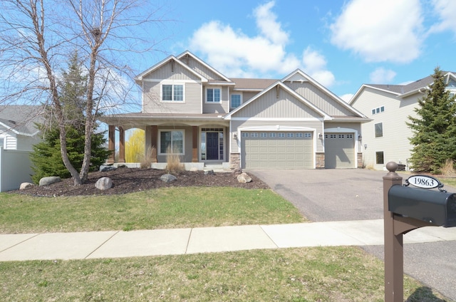 craftsman house with covered porch, driveway, stone siding, board and batten siding, and an attached garage