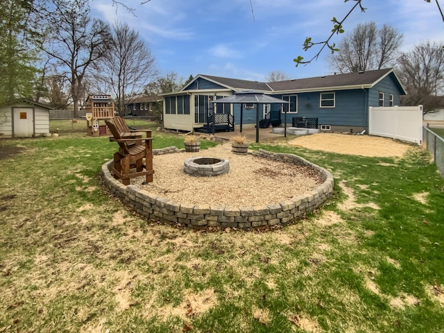 1005 Honeysuckle Ln, Farmington, MN 55024 - back of property with a sunroom, an outdoor fire pit, a shed, a playground, and a gazebo