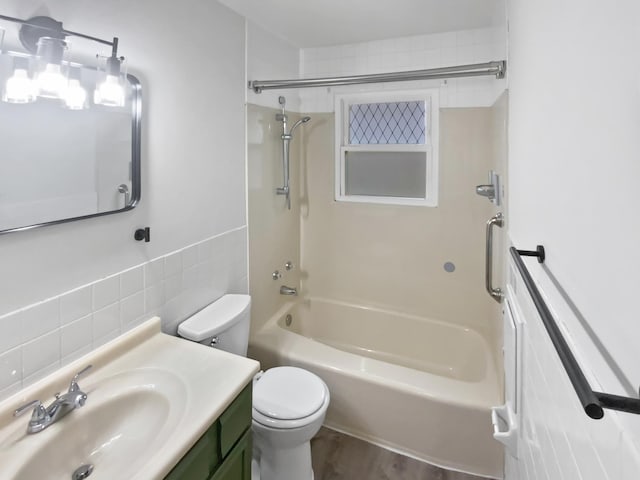 1005 Honeysuckle Ln, Farmington, MN 55024 - full bathroom featuring tile walls, washtub / shower combination, vanity, toilet, and wood finished floors